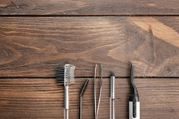 Tools for eyebrow dyeing and correction on wooden background