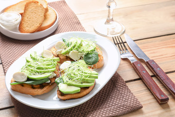 Tasty bruschettas with avocado slices on plate