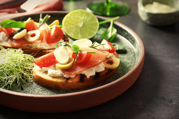 Tasty bruschettas with prosciutto, tomatoes and mozzarella on plate