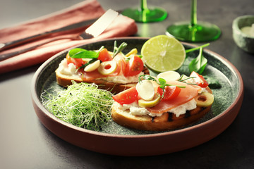 Tasty bruschettas with prosciutto, tomatoes and mozzarella on plate