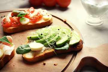 Fototapeta na wymiar Tasty bruschetta with avocado and mozzarella on wooden board