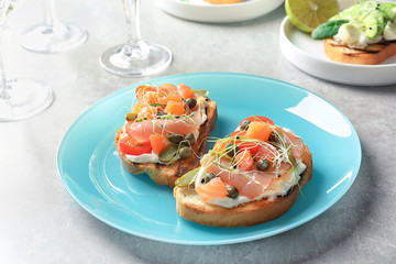 Tasty bruschettas with prosciutto on plate
