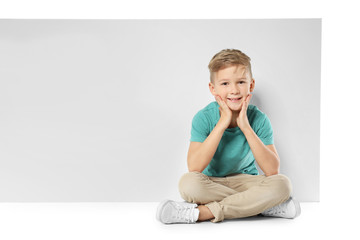 Cute boy with blank advertising board on white background