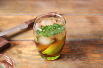 Glass with Cuba Libre cocktail on wooden table