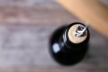 Opening bottle of wine with corkscrew, closeup