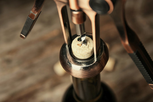 Opening bottle of wine with corkscrew, closeup