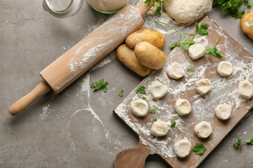 Fototapeta premium Raw dough for dumplings on wooden board