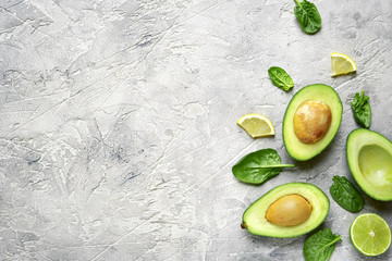 Avocado halves with lime slices and baby spinach leaves .Top view with copy space.