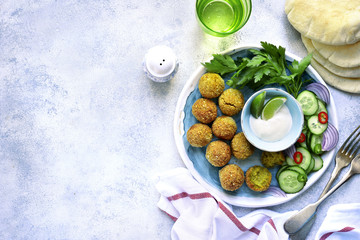 Homemade spicy chickpea falafel garnished with fresh vegetable and yogurt.Top view.