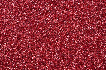 A huge amount of red decorative sequins. Background texture with shiny, small elements that reflect...