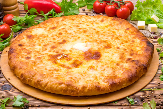 Ossetian cheese pie on a wooden background 