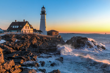 A vibrant morning on Maine's coast at sunrise with a lighthouse.