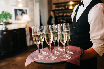 waiter brings glasses of champagne