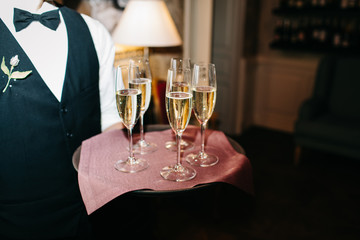 waiter brings glasses of champagne