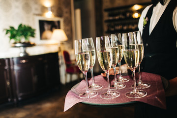waiter brings glasses of champagne