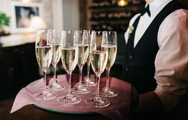 waiter brings glasses of champagne