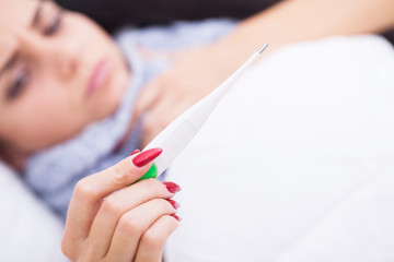 Obraz na płótnie Canvas Flu. Close-up of female’s hand holding thermometer