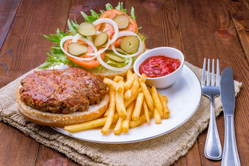 open hamburger with french fries on wooden background