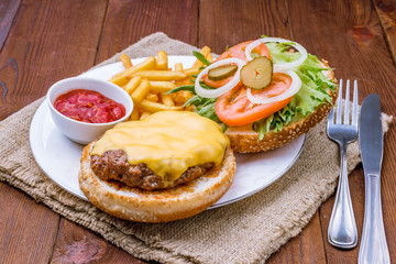 open cheeseburger on wooden background