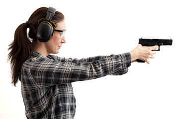 Second amendment, self defence and use of firearms at shooting range concept with a woman aiming a gun and ready to shoot while wearing protective gear isolated on white with a clipping path included