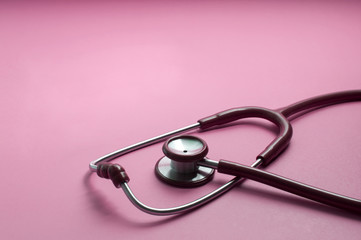 Red stethoscope on pink background Health care concept