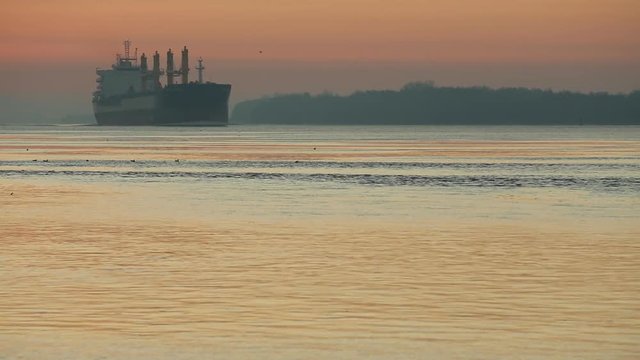 Fraser River Morning Freighter. A freighter heading out into Georgia Strait at sunrise. British Columbia, Canada, near Vancouver.

