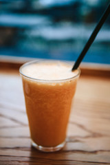 Fresh orange juice on a table in a cafe next to the window. Useful morning drink.