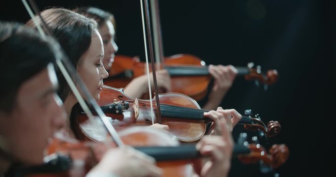 string quartet performs on stage, close-up of violin in work