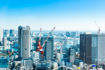 Asia Business concept for real estate and corporate construction - panoramic modern city skyline bird eye aerial view with crane near tokyo tower under bright sun and vivid blue sky in Tokyo, Japan