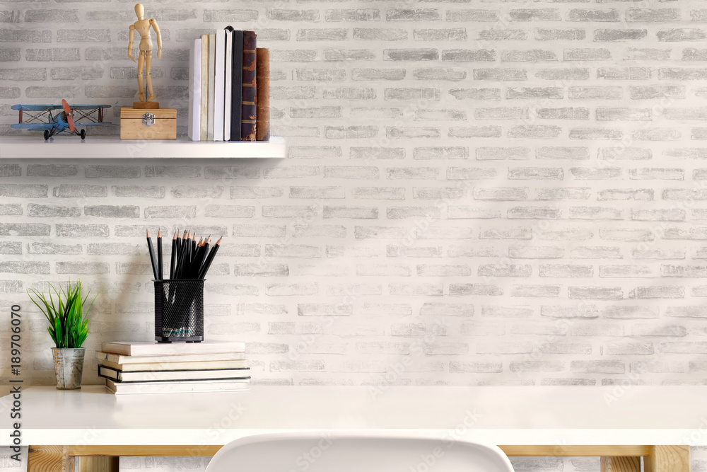 Poster front view of minimal desk and designer tools over white brick wall. copy space for product display 