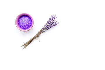 Cosmetics for skin care and relaxation. Lavender violet spa salt on white background top view copy space