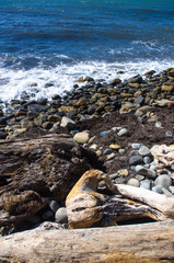 rocky sea shore with pebble beach, waves with foam