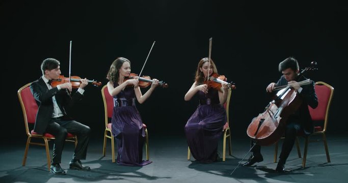 classical string quartet during the performance of the symphony, abstract black background