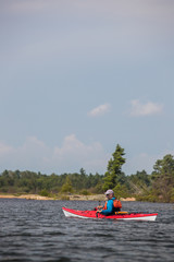 Active senior paddling a sea kayak