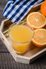 Fresh Orange Juice in Glass in Wooden Tray on old wooden table background. Citrus Drink Lemonade. Copy space