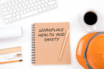 Work safety concept. Top viwe of modern workplace with safety helmet, office supplies, a cup of coffee and keyboard on white background.