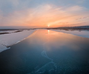 shooting with quadrocopter winter landscape evening sunset over the frozen river aerial photography
