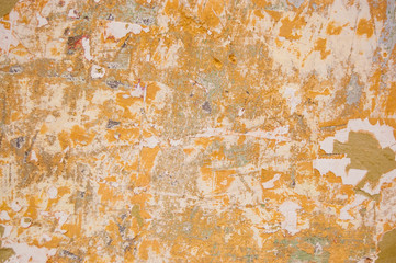 peeling paint wall painted with ocher, grey and orange colors