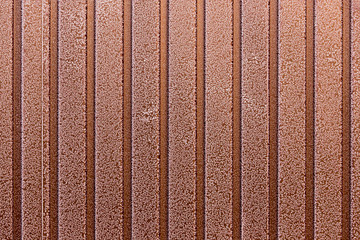 A snowflake on a brown fence as a background