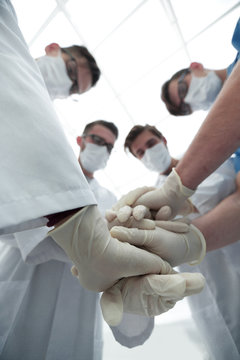 Doctors and nurses stacking hands.