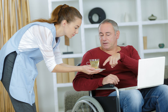 carer serving a cup of tea to patient