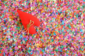 red heart made of fabric on a background of multicolored confetti