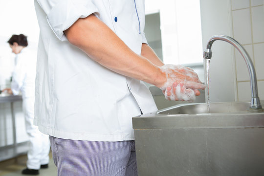 chefs washing hands in an industrial kitchen