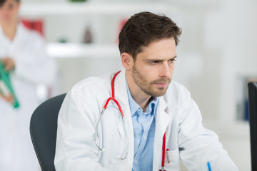 handsome young doctor at work in his office
