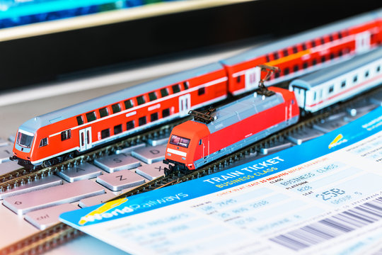 Toy train, tickets, passport and bank card on laptop or notebook