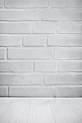Light gray grunge textured brick wall and wooden floor