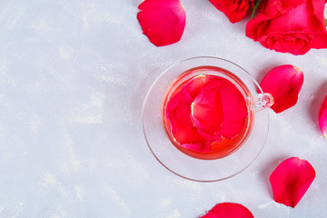 tea made from tea rose petals in a glass bowl on grey table.