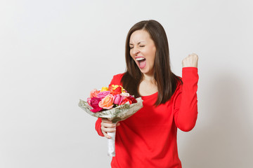 Young woman in red clothes holding bouquet of beautiful roses flowers, doing winner gesture isolated on white background. St. Valentine's Day or International Women's Day, birthday, holiday concept.
