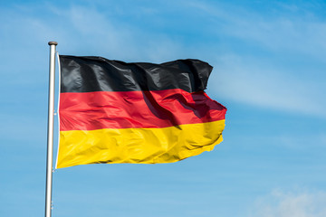 German flag waggling in the wind with sky in background