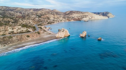 Obraz premium Widok z lotu ptaka ptaka Petra tou Romiou, skała aka Aphrodite's słynny punkt orientacyjny podróży turystycznych w Paphos, Cypr. Zatoka morska bogini Afroditi miejsce narodzin o zachodzie słońca z góry.